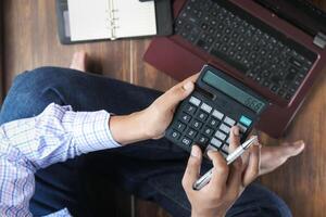 work from home concept, Top view of man using calculator. photo