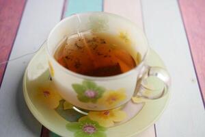 green tea and tea bag on table, close up. photo