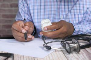 doctor writing documents at desk in clinics . photo