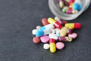 Close up of many colorful pills and capsules on black background photo