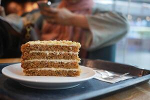 caramel cake on cafe table and a woman sitting on background photo