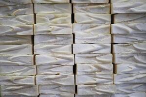 A stack of white soaps with blue ribbons in a basket photo