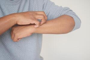 man suffering from itching skin, close up. photo