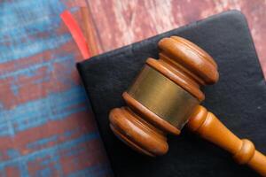 Top view of gavel on a book on wooden background photo