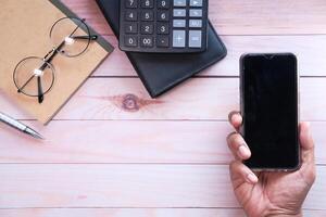 man holding smartphone with empty screen, high angle view photo
