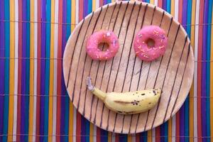 gracioso sonriente cara rosquilla en plato foto