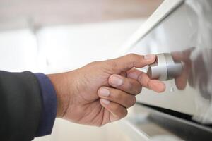 cerca arriba de hombres mano ajuste temperatura controlar en horno. foto