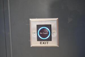 Close up of an exit button on a hardwood door in electric blue font photo