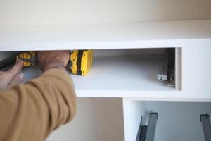 Man installing wooden shelves on brackets wall installing a shelf photo