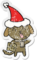 cute hand drawn distressed sticker cartoon of a dog with christmas present wearing santa hat png
