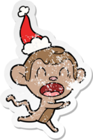 shouting hand drawn distressed sticker cartoon of a monkey wearing santa hat png