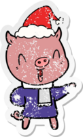 happy hand drawn distressed sticker cartoon of a pig in winter clothes wearing santa hat png