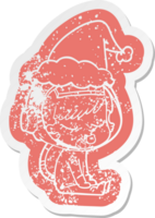 quirky cartoon distressed sticker of a pretty astronaut girl sitting waiting wearing santa hat png