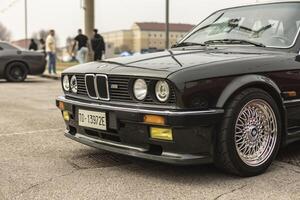 Vicenza Italy 19 March 2024 A black BMW vehicle is parked in a designated spot within a parking lot surrounded by other empty parking spaces photo