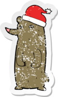 retro distressed sticker of a cartoon bear in xmas hat png