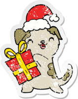 adesivo angustiado de um cachorrinho fofo de desenho animado com presente de natal e chapéu png