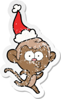 hand drawn distressed sticker cartoon of a surprised monkey wearing santa hat png