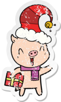 autocollant en détresse d'un cochon de dessin animé heureux avec un cadeau de Noël png