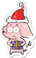 hand drawn distressed sticker cartoon of a unsure elephant with christmas present wearing santa hat png