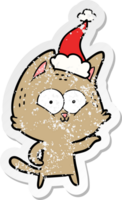 mano dibujado afligido pegatina dibujos animados de un gato vistiendo Papa Noel sombrero png