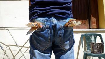 50 and 20 euro banknotes sticking out of the pockets of a blue jeans photo