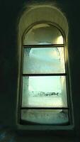 A window that is almost completely covered in ice crystals on a sunny day photo