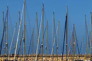 Masts in the port against the blue sky. photo