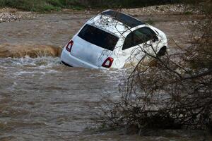 The car was carried away by a strong rain flow of water. photo