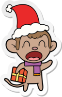 shouting sticker cartoon of a monkey carrying christmas gift wearing santa hat png