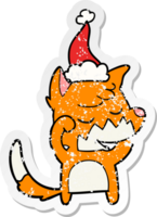 friendly hand drawn distressed sticker cartoon of a fox waking up wearing santa hat png