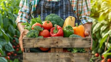 Farmer holding wooden box of healthy vegetables photo