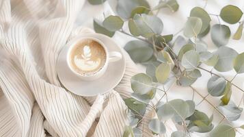 capuchino taza con eucalipto en el mesa foto