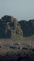 A large rock formation in the middle of a desert video