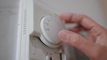 Woman checks temperature with thermometer and adjusts heat with timer. video