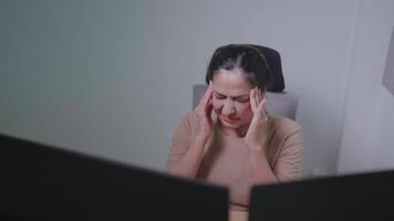 asiatico donne sentire stanco, irritata, e sovraccarico di lavoro. e occhio sforzo dopo utilizzando il computer per opera a partire dal casa. male alla testa. visivo fatica. e sintomi di occhio fatica video