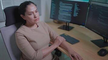 Close-up of a self-employed woman sitting and writing code, discouraged, tired of computer technology, programmer work, tired. video