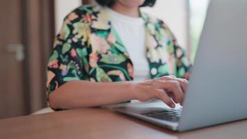 jong vrouw artikel auteur is creëren haar verhaal. gekleed omhoog, stijlvol, zittend Bij de tafel typen Aan een laptop computer. video