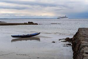 Traditional Irish Currach wooden boats on Salthill beach ready for racing, nature and seascape background, Galway, Ireland photo