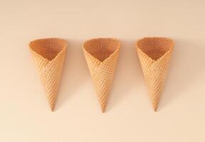Ice cream cones on pastel cream background. Summer creative concept. Minimal sweet layout. Summer food aesthetic. Flat lay. photo