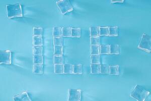 Word ICE made of ice cubes on light blue background. Minimal summer drink concept. Creative summertime composition. Flat lay, top of view. photo