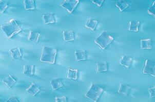 Ice cubes pattern on light blue background. Minimal summer drink concept. Trendy summertime pattern backdrop. Flat lay, top of view. photo