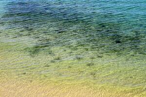 The color of water in the Mediterranean Sea in shallow water. Natural abstract background. photo