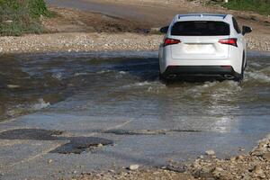 The car was carried away by a strong rain flow of water. photo