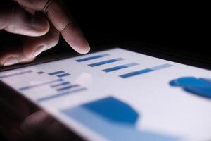 person hand analyzing financial data in digital tablet photo