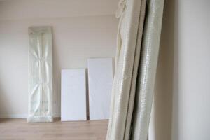 An empty room with hardwood flooring and wrapped in plastic. photo