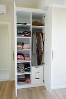 organizing clothes in a closet on shelves for comfort and ease of access photo
