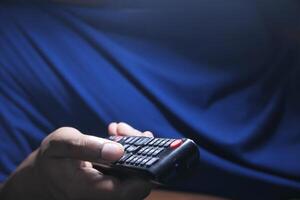 close up of man hand holding tv remote. photo