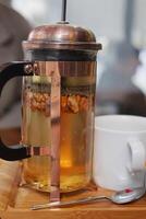 Tableware set with French press, cup, and spoon for serving tea at home photo