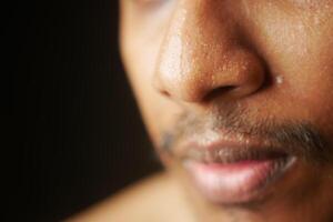 closeup of sweat on nose against dark background , photo