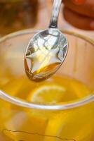 torrencial miel en un taza de té foto
